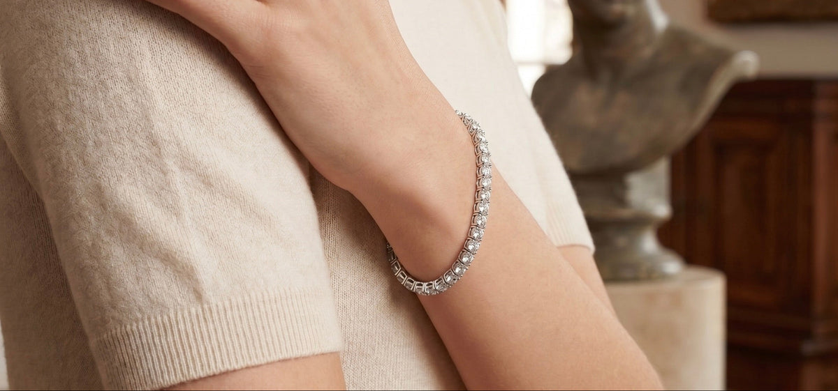 Close-up of a person wearing a white gold diamond bracelet on a blurred background
