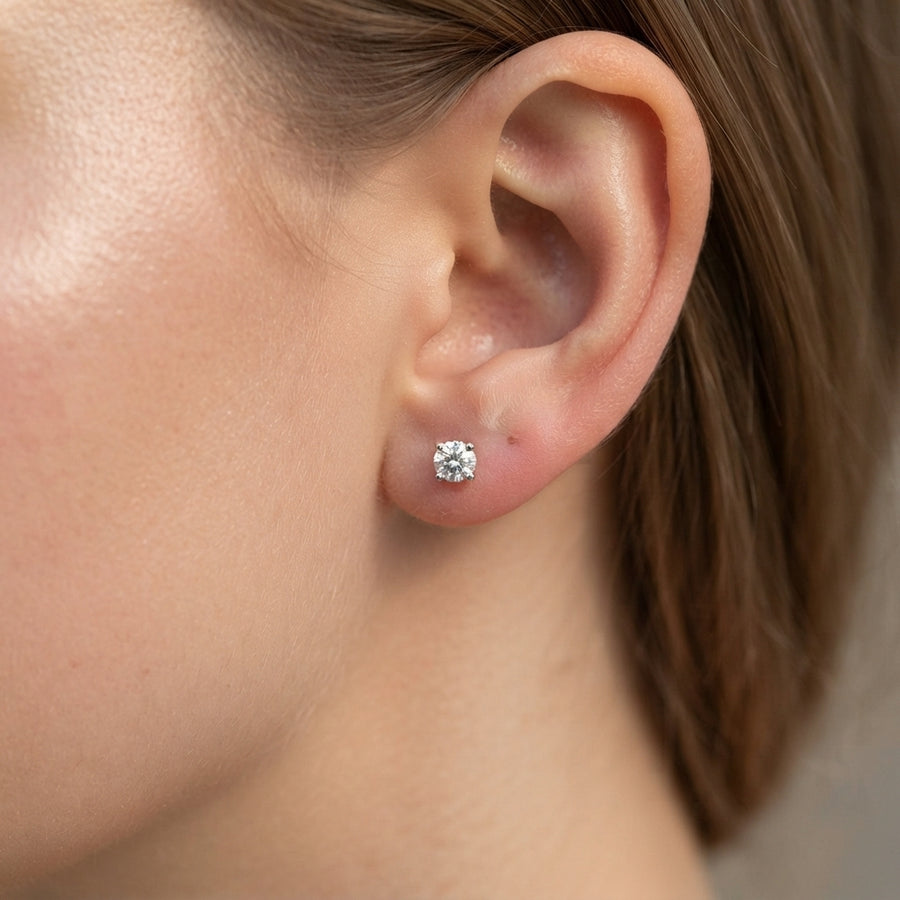 Classic diamond stud earring on a girl earlobe 