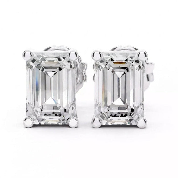 A pair of emerald-cut diamond stud earrings in white gold setting, shown against a plain white background.