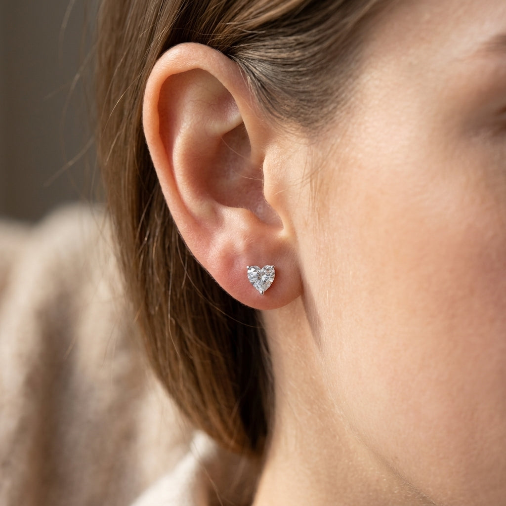 Heart-cut diamond stud earrings on a girl earlobe