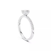 A white gold diamond engagement ring with a round-cut center stone and a pavé band, shown on a clean white background.