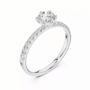 A white gold solitaire engagement ring with a round-cut center stone and a pavé-set band, shown on a clean white background.