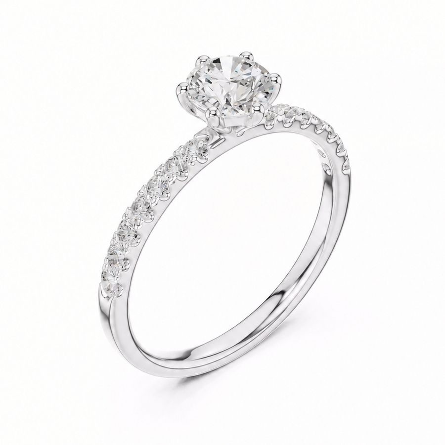 A white gold solitaire engagement ring with a round-cut center stone and a pavé-set band, shown on a clean white background.