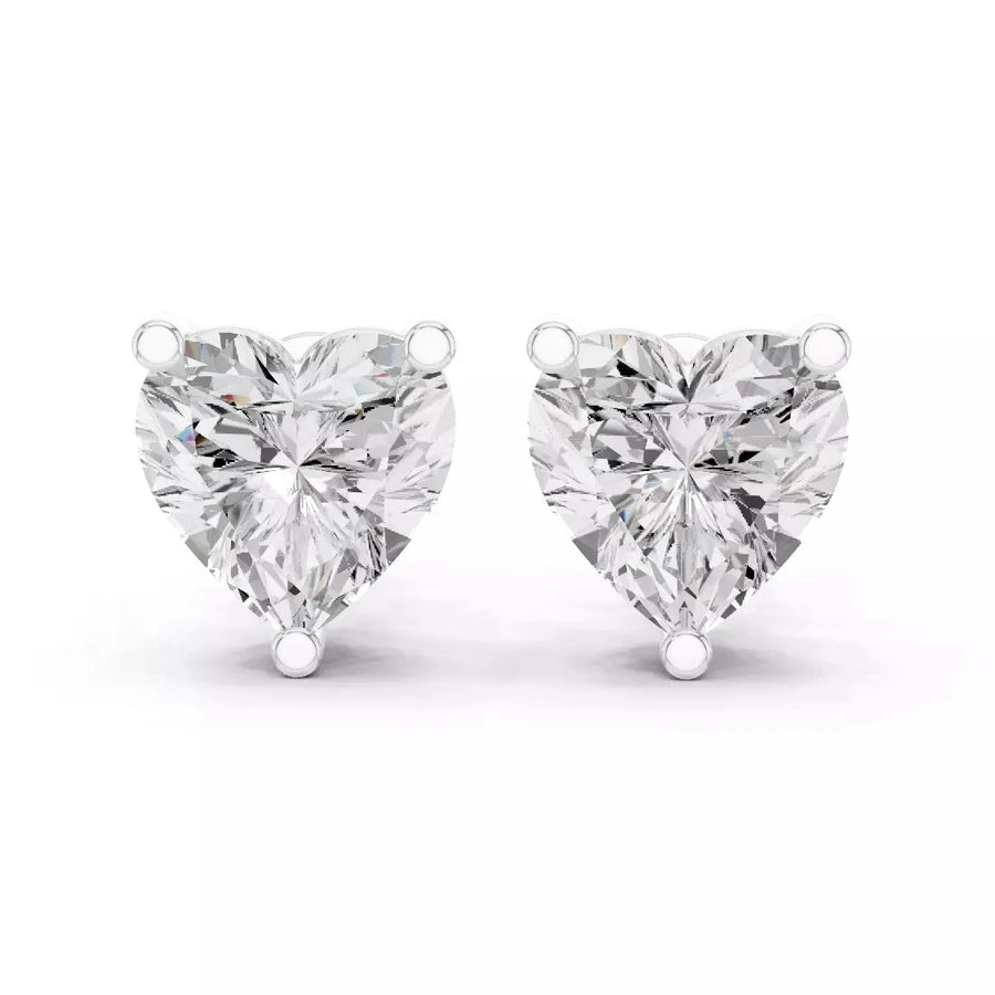 A pair of heart-shaped diamond stud earrings in white gold setting, photographed on a clean white background.