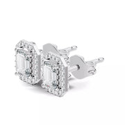 A pair of white gold stud earrings featuring large emerald-cut clear gemstones surrounded by smaller accent stones, shown on a clean white background.